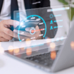 Man wearing suit using phone and laptop with hovering digital imagine above keyboard showing speed test levels
